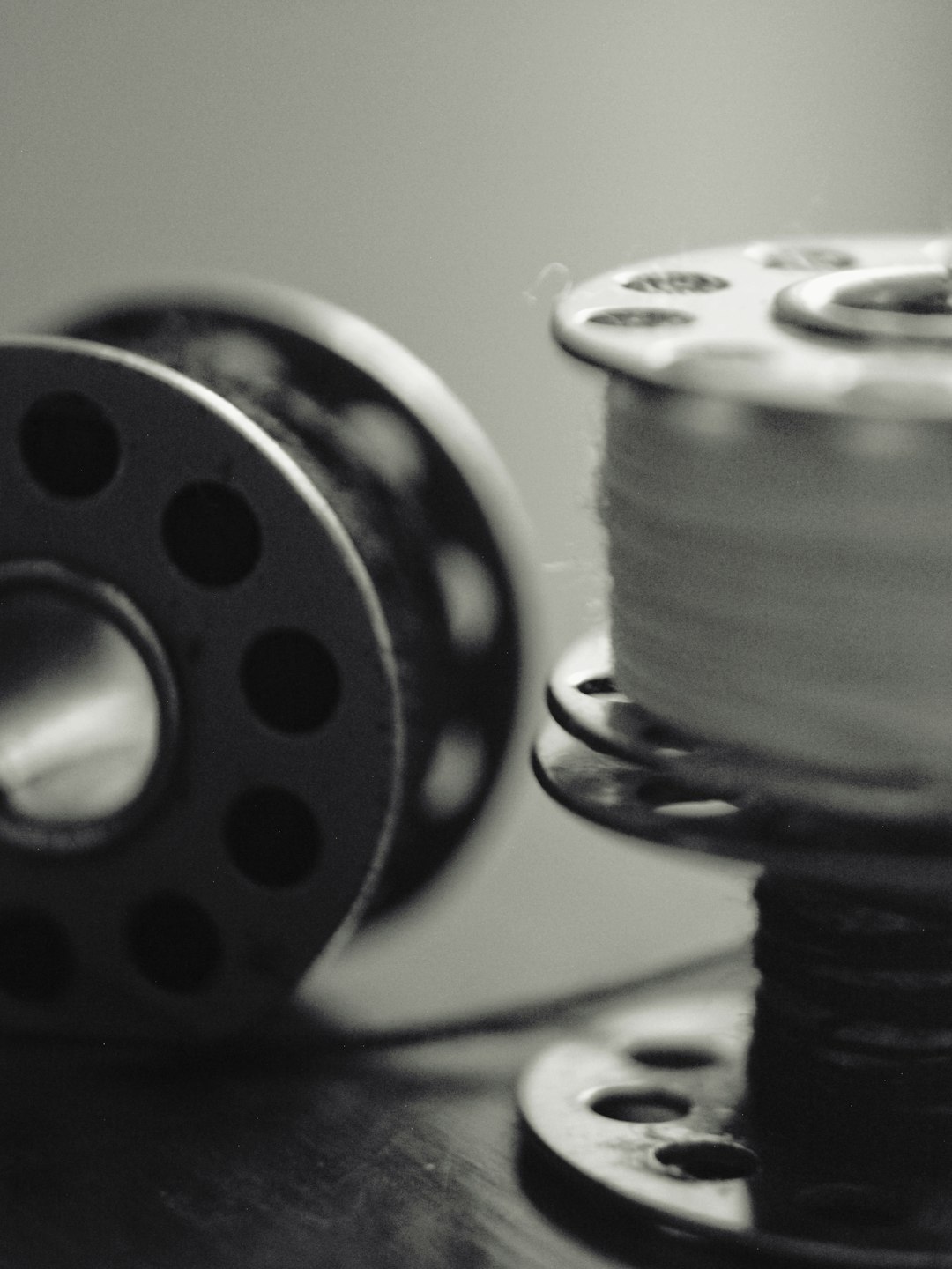 about-us-01 two-sewing-bobbins-one-with-thread-in-black-and-white-ise2njjafjc